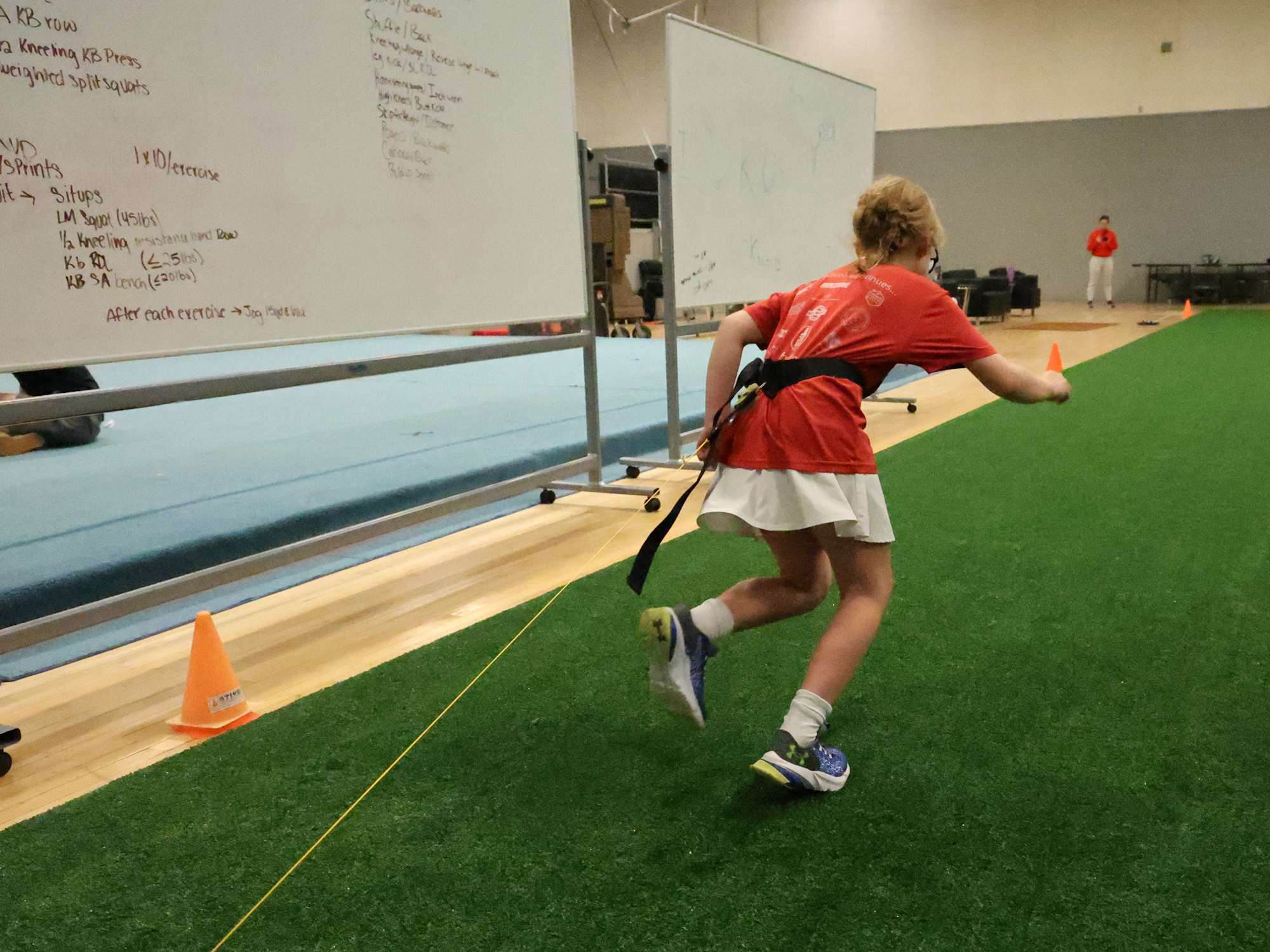 A young athlete sprints while attached to measuring devices. 