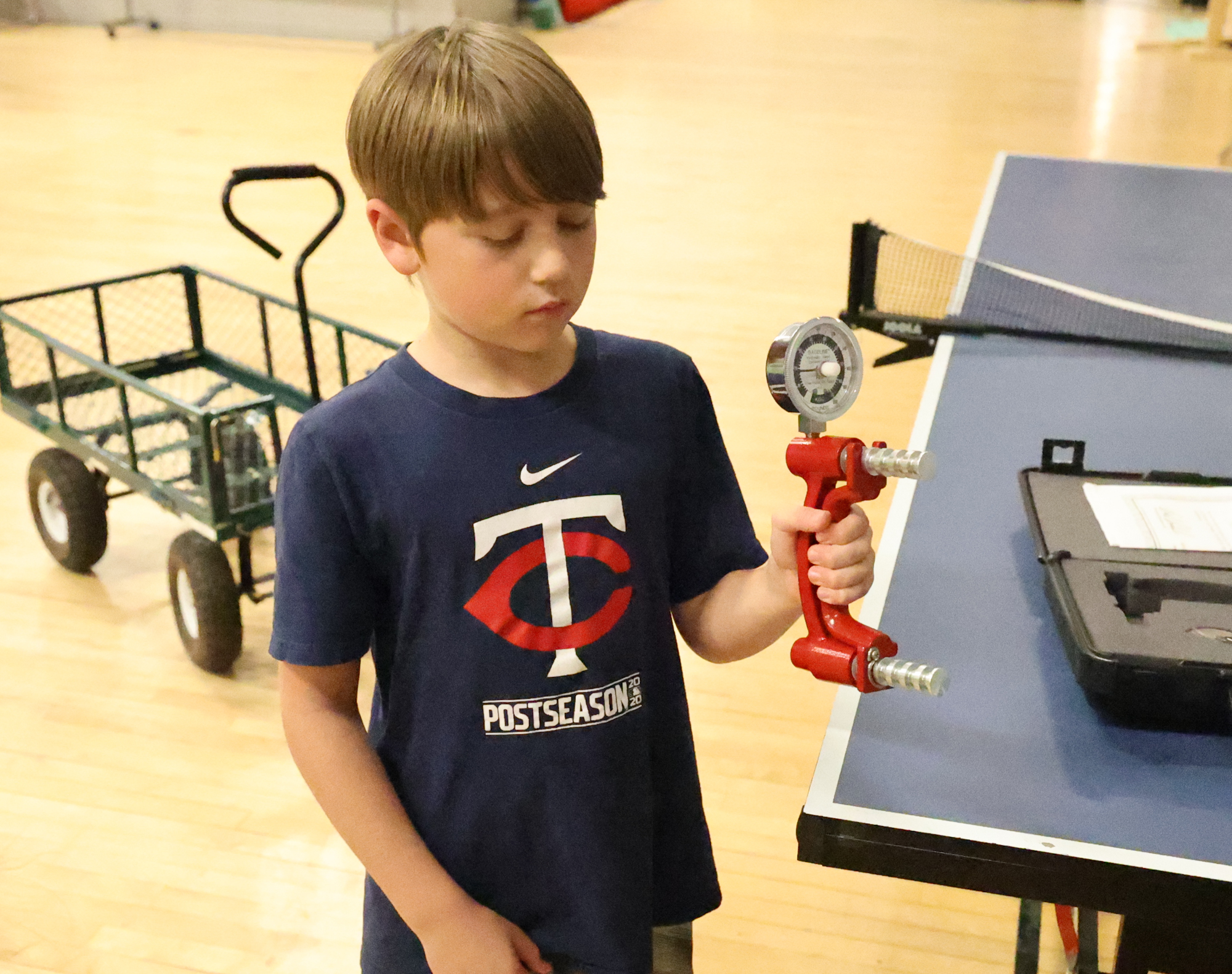 A young athlete tests their grip strength on a device. 