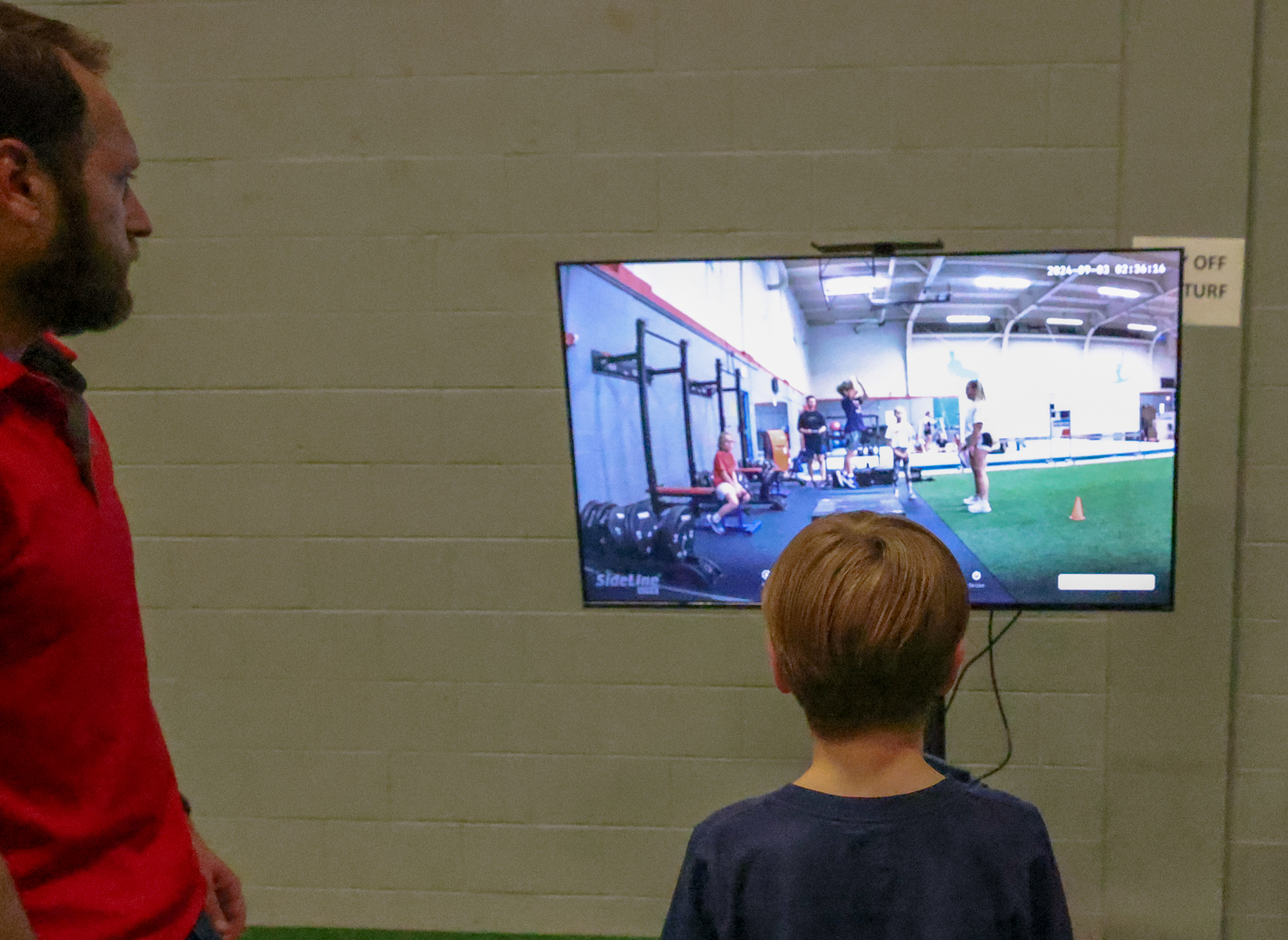 A young athlete and a sideline scout work at sport performance measuring devices.